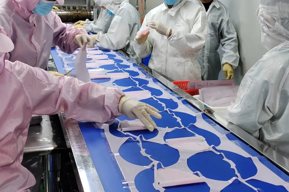 Operario de producción en línea de fábricación de mascarillas faciales